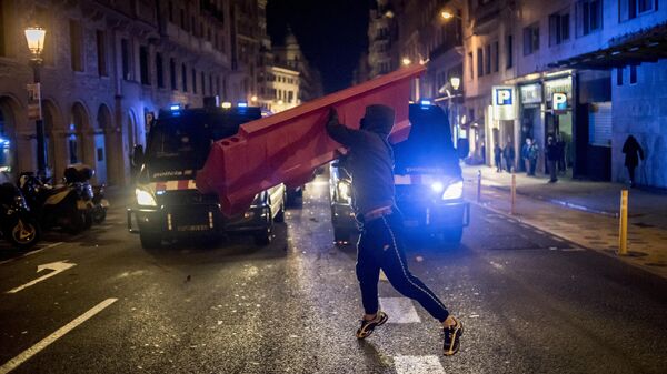 Участник акции протеста в поддержку рэпера Пабло Аселя, приговоренного к девяти месяцам заключения за оскорбление монархии и прославление леворадикального терроризма, на одной из улиц в Барселоне.