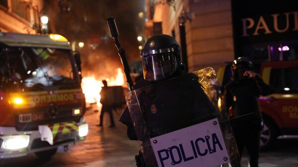 Сотрудник полиции во время акции протеста в поддержку рэпера Пабло Аселя, приговоренного к девяти месяцам заключения за оскорбление монархии и прославление леворадикального терроризма, на площади Пуэрта-дель-Соль в Мадриде