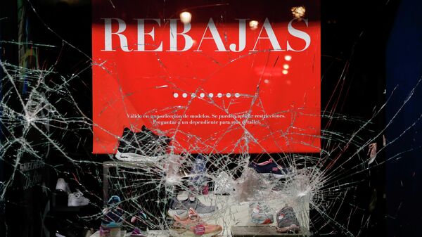 Разбитое окно обувного магазина во время акции протеста в поддержку рэпера Пабло Аселя в Мадриде