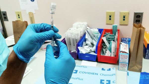 Медработник готовит шприц с вакциной Pfizer-BioNTech  на участке вакцинации COVID-19 в NYC Health + Hospitals Metropolitan в Нью-Йорке