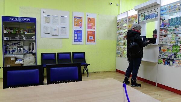 Покупатель у первого аптечного пункта, открытого при московском отделении Почты России