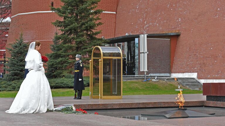 Молодожены у Вечного огня и Могилы Неизвестного солдата в Александровском саду в Москве