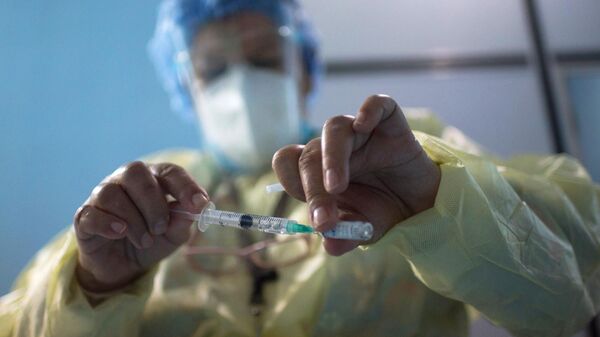 Медицинский работник набирает в шприц препарат Гам Ковид Вак от коронавирусной инфекции