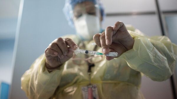 Медицинский работник одной из больниц Каракаса набирает в шприц российский препарат Гам Ковид Вак (Sputnik V)