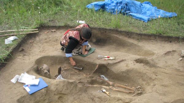 Специалист СФУ зачищает погребение бронзового века