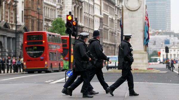 Полицейские переходят дорогу у здания Министерства иностранных дел и международного развития в Лондоне