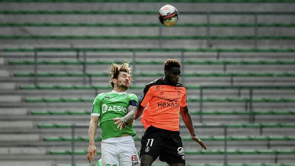Reims' French midfielder Boulaye Dia (R) fights for the ball with Saint-Etienne's French defender Mathieu Debuchy (L) during the French L1 football match AS Saint-Etienne (ASSE) vs Stade de Reims (SR) on February 20, 2021, at the Geoffroy Guichard stadium in Saint-Etienne. (Photo by JEFF PACHOUD / AFP)