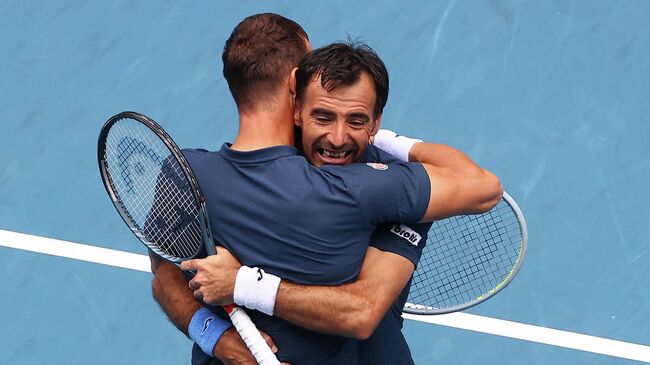 Теннисисты Иван Додиг и Филип Полашек празднуют победу на Australian Open.