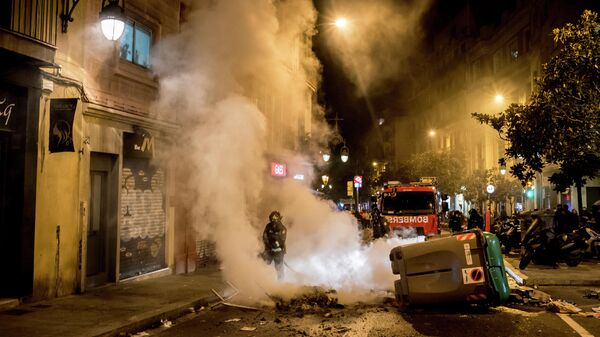 Пожарные тушат огонь во время акции протеста в связи с задержанием рэпера Пабло Аселя в Барселоне
