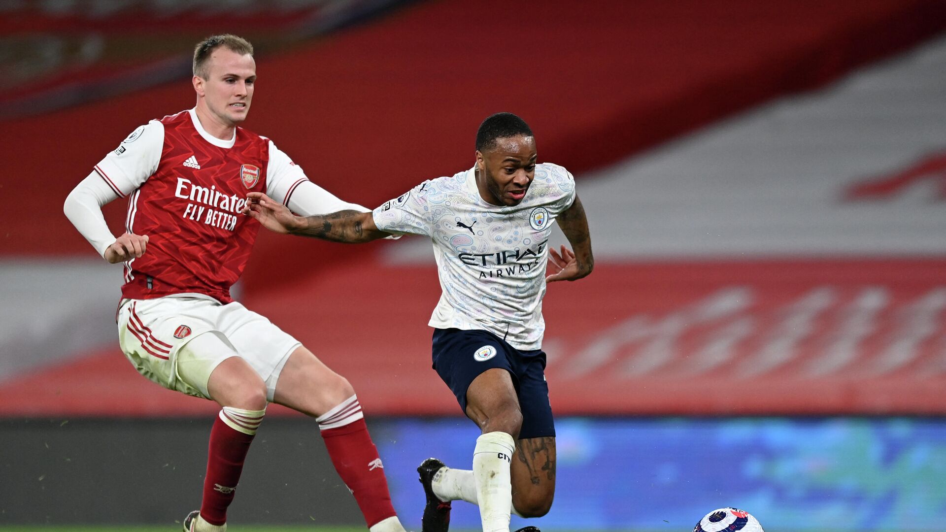 Arsenal's English defender Rob Holding (L) vies with Manchester City's English midfielder Raheem Sterling (R) during the English Premier League football match between Arsenal and Manchester City at the Emirates Stadium in London on February 21, 2021. (Photo by Shaun Botterill / POOL / AFP) / RESTRICTED TO EDITORIAL USE. No use with unauthorized audio, video, data, fixture lists, club/league logos or 'live' services. Online in-match use limited to 120 images. An additional 40 images may be used in extra time. No video emulation. Social media in-match use limited to 120 images. An additional 40 images may be used in extra time. No use in betting publications, games or single club/league/player publications. /  - РИА Новости, 1920, 21.02.2021