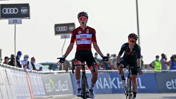 UAE Team Emirates' Slovenian cyclist Tadej Pogacar celebrates upon crossing the finish line to win the third stage of the UAE Cycling Tour from Al Ain to Jebel Hafeet on February 23, 2021. (Photo by Giuseppe CACACE / AFP)