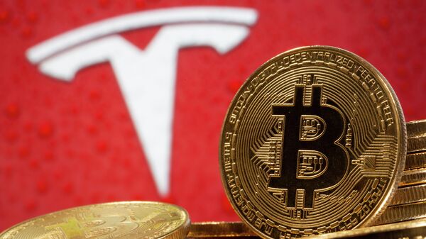 Криптовалюта биткоин на фоне иллюстрации с логотипом Tesla