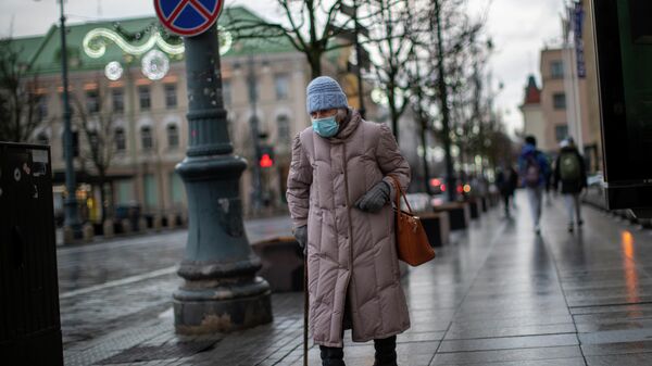 Пожилая женщина в защитной маске на улице Вильнюса
