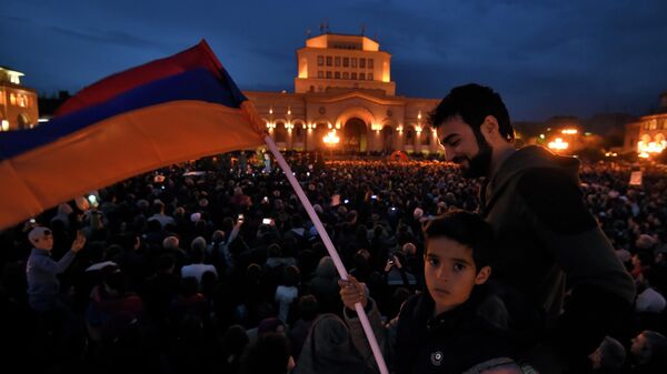 Люди с национальным флагом во время акции протеста на площади Республики в Ереване. 2018 год