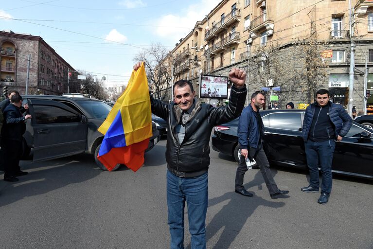 Мужчина с национальным флагом на проспекте Баграмяна в Ереване