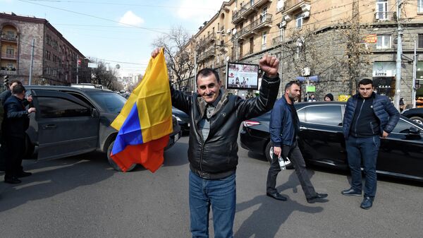 Мужчина с национальным флагом на проспекте Баграмяна в Ереване
