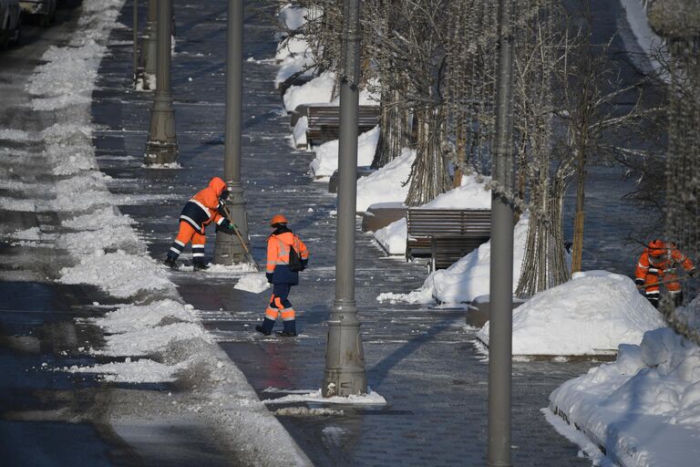 Сотрудники коммунальных служб чистят снег в центре Москвы