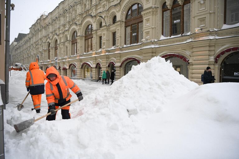 Работники коммунальной службы убирают снег на Никольской улице в Москве