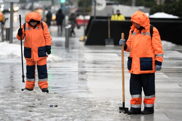 Сотрудники коммунальных служб убирают снег на одной из улиц Москвы