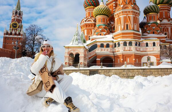 Девушка фотографируется возле храма Василия Блаженного в Москве