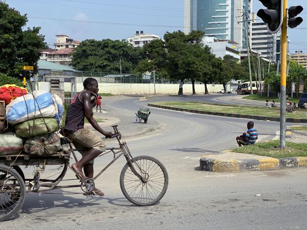Мужчина едет на велосипеде в городе Дар-эс-Салам в Танзании.