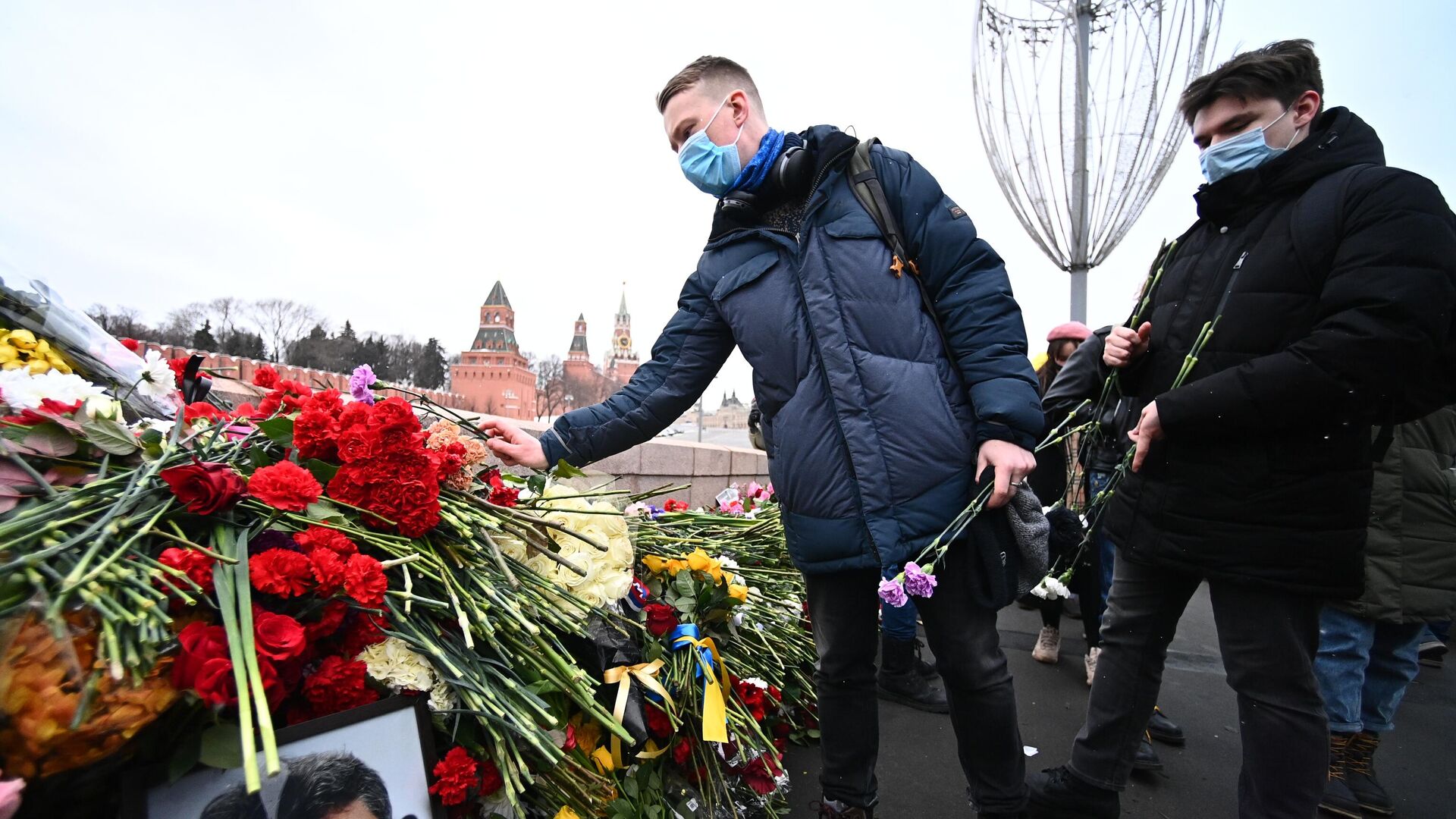Молодые люди возлагают цветы на месте гибели политика Бориса Немцова на Большом Москворецком мосту в Москве - РИА Новости, 1920, 27.02.2021