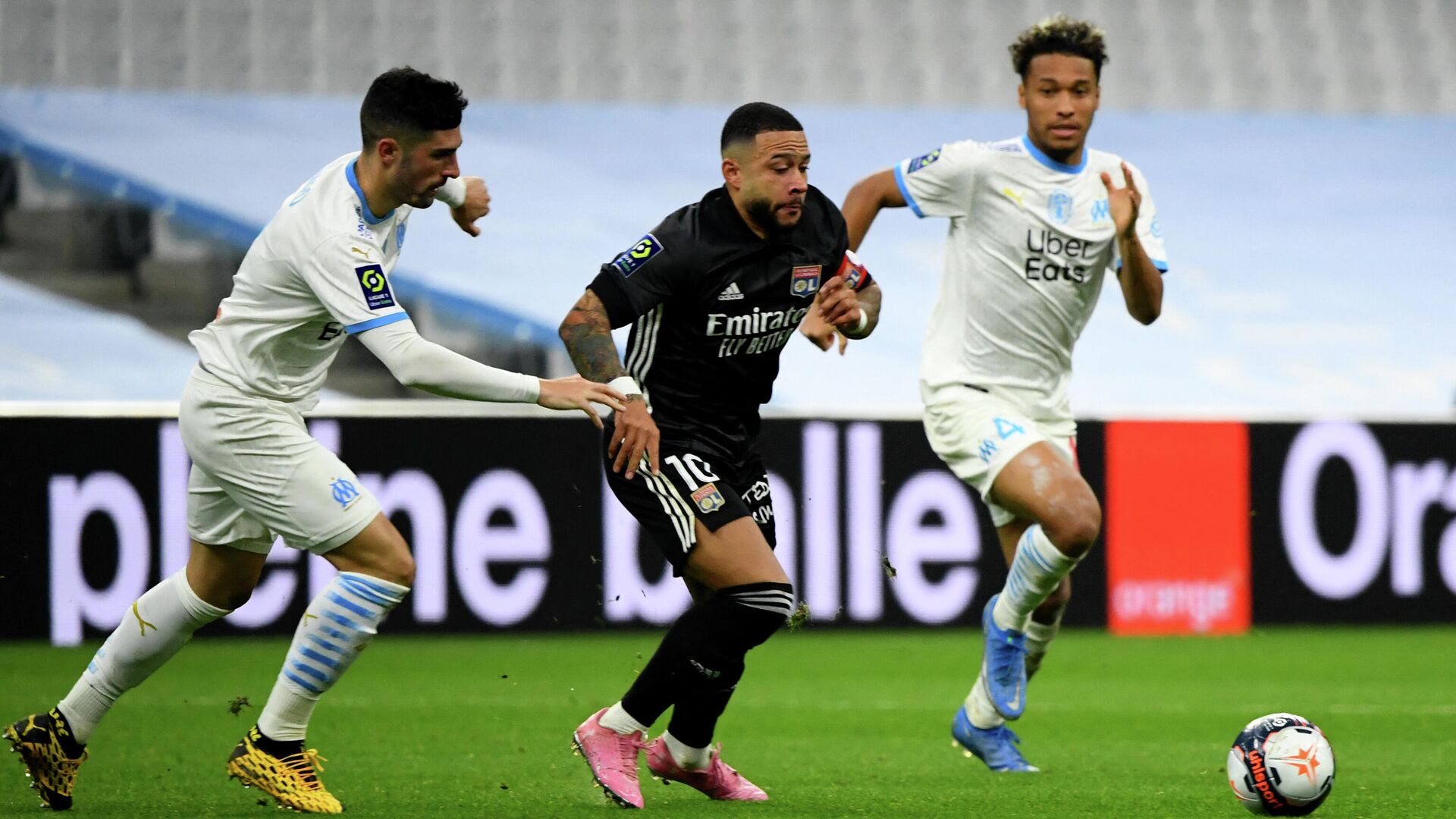 Lyon's Dutch forward Memphis Depay (C) fights for the ball during the French L1 football match between Olympique de Marseille (OM) and Olympique Lyonnais (OL) at the Velodrome stadium in Marseille on February 28, 2021. (Photo by CLEMENT MAHOUDEAU / AFP) - РИА Новости, 1920, 01.03.2021