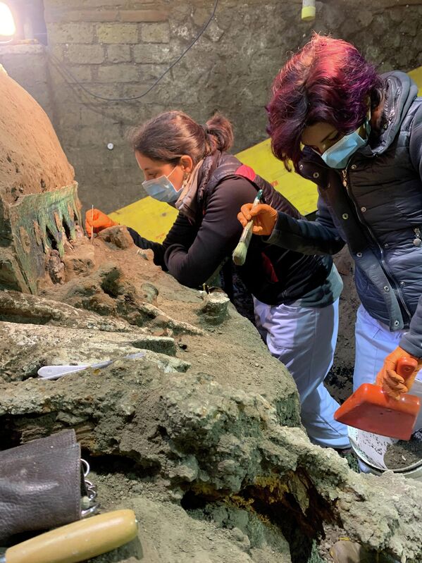 Археологи во время раскопок большой четырехколесной церемониальной колесницы, обнаруженной на месте древнеримского города Помпеи