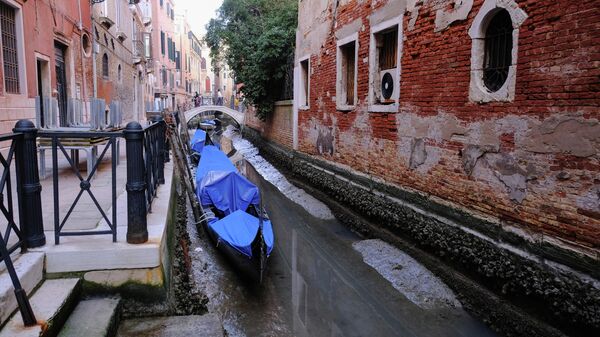 Гондолы в канале во время отлива в Венеции, Италия