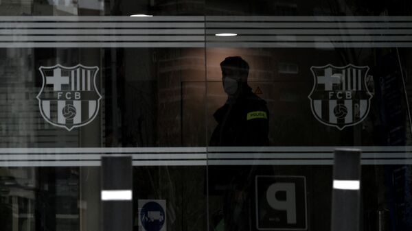 A policeman stands in the offices of the Barcelona Football Club on March 01, 2021 in Barcelona during a police operation inside the building. - Police raided the offices of FC Barcelona on March 01, 2021, carrying out several arrests just six days ahead of the club's presidential elections, a Catalan regional police spokesman told AFP. Spain's Cadena Ser radio said one of those arrested was former club president Josep Maria Bartomeu, who resigned in October, along with CEO Oscar Grau and the club's head of legal services. (Photo by LLUIS GENE / AFP)