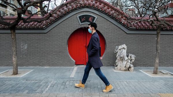 Мужчина на одной из улиц через год после начала пандемии в Пекине