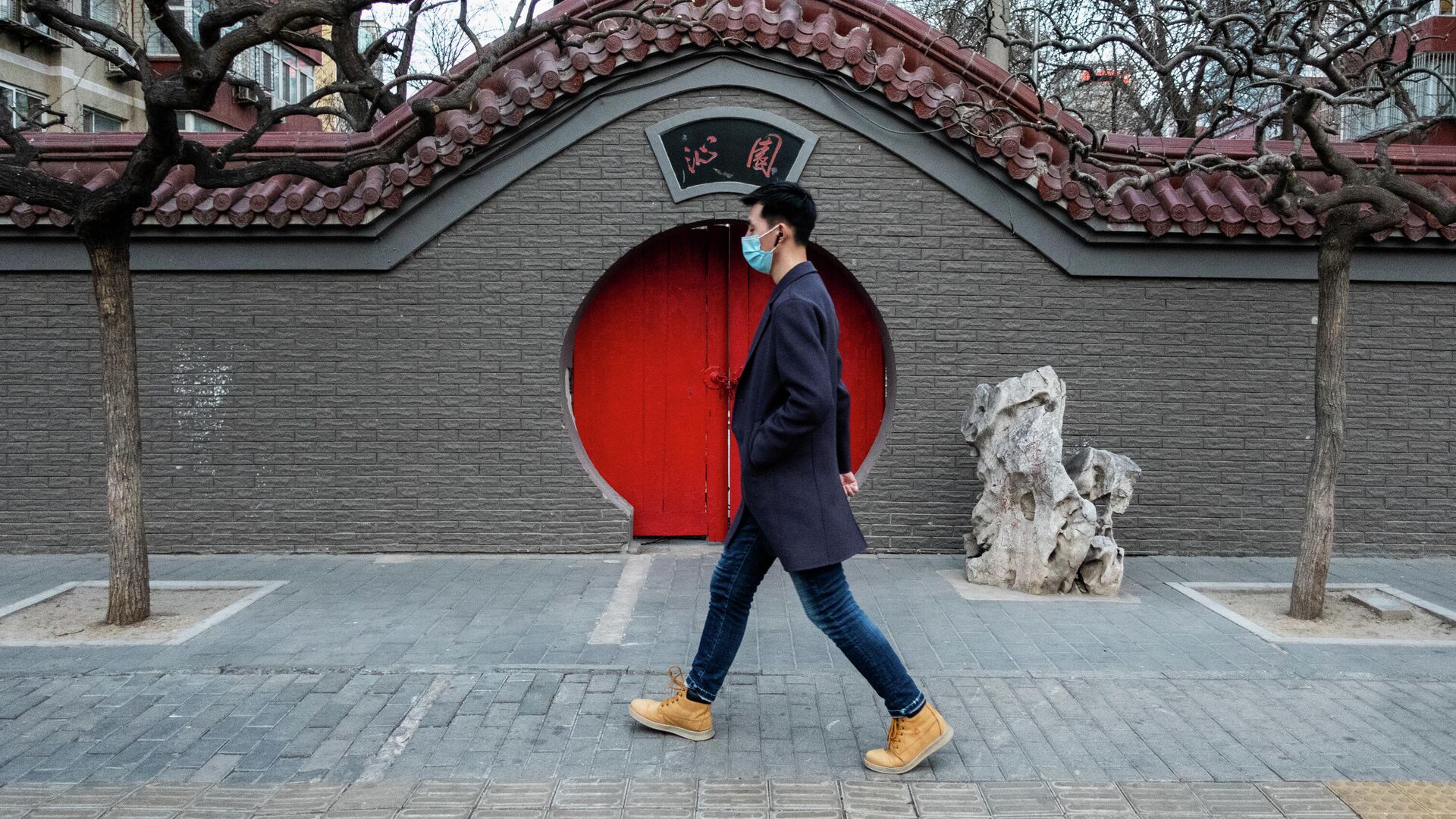Мужчина на одной из улиц через год после начала пандемии в Пекине - РИА Новости, 1920, 07.03.2021