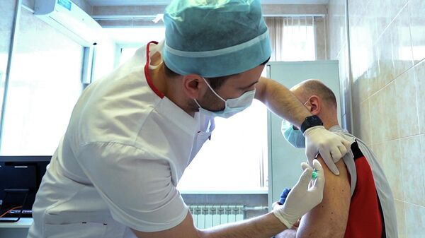 Медицинский работник вводит вакцину Спутник Лайт добровольцу во время клинических исследований