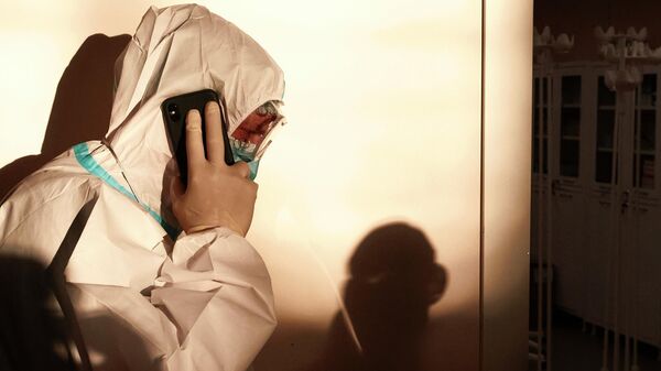 Медицинский работник разговаривает по телефону во временном госпитале для больных COVID-19, организованном в выставочном комплексе Ленэкспо