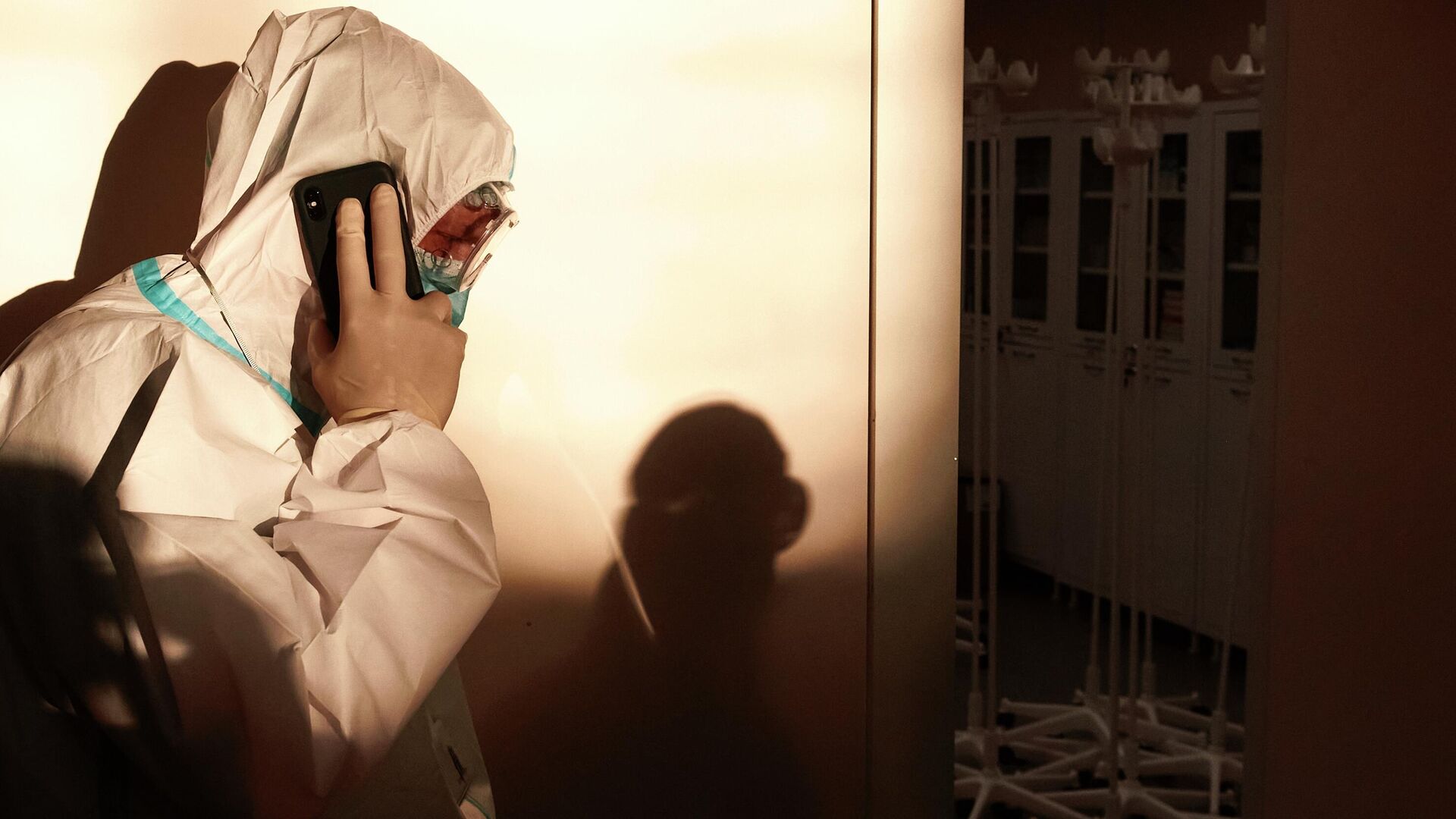 Медицинский работник разговаривает по телефону во временном госпитале для больных COVID-19, организованном в выставочном комплексе Ленэкспо - РИА Новости, 1920, 07.04.2021