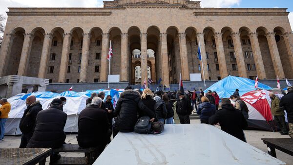 Активисты оппозиционных партий и организаций, требующие проведения внеочередных парламентских выборов и освобождения политзаключенных, в палаточном городке у здания парламента Грузии в Тбилиси