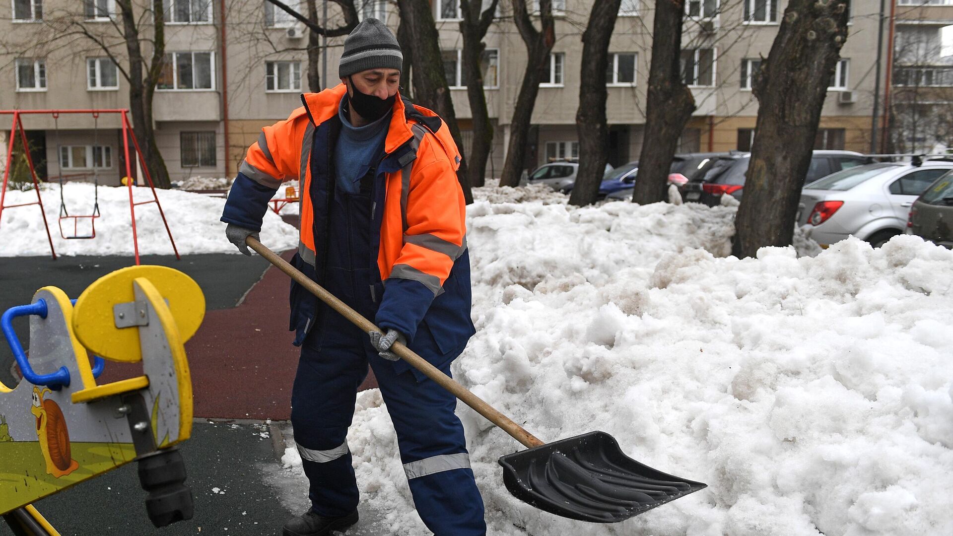 Сотрудник коммунальной службы убирает снег на одной из улиц в Москве - РИА Новости, 1920, 17.01.2022