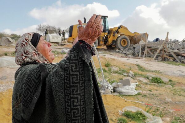 Женщина смотрит, как сносят ее дом около Хеброна на Западном берегу реки Иордан