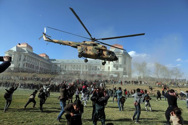 Военный вертолет пролетает над людьми во время выставки в Кабуле 