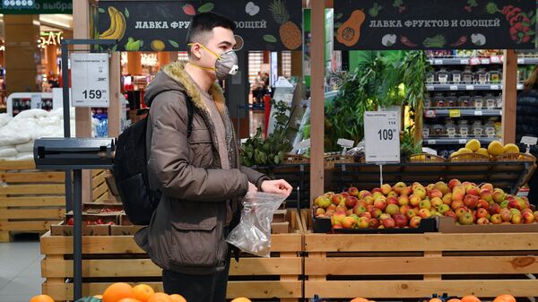 Покупатель выбирает фрукты в одном из супермаркетов сети Перекресток города Москвы