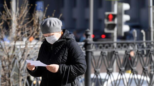 Женщина в защитной маске на одной из улиц в Москве