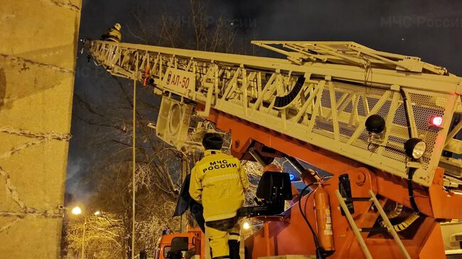 Сотрудники МЧС на месте пожара в многоэтажном доме в Уфе