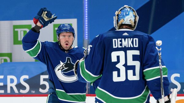 VANCOUVER, BC - MARCH 08: Jayce Hawryluk #13 of the Vancouver Canucks congratulates teammate Thatcher Demko #35 after defeating the Montreal Canadiens 2-1 in a shootout in NHL hockey action at Rogers Arena on March 8, 2021 in Vancouver, Canada.   Rich Lam/Getty Images/AFP (Photo by Rich Lam / GETTY IMAGES NORTH AMERICA / Getty Images via AFP)