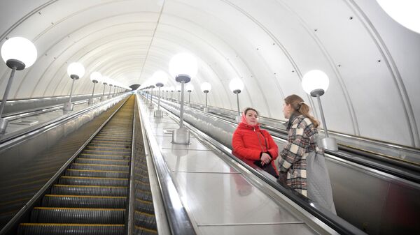 Женщины на эскалаторе станции метрополитена Парк Победы в Москве