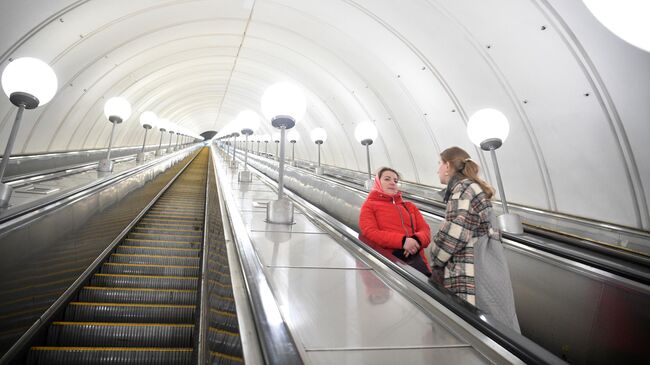 Женщины на эскалаторе станции метрополитена Парк Победы в Москве