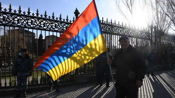 Участник митинга оппозиции перед зданием Национального собрания Армении в Ереване