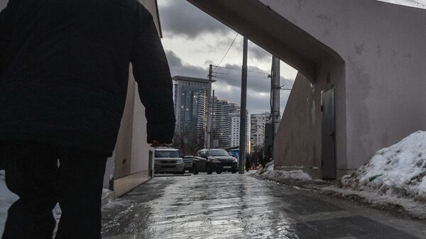 Мужчина идет по тротуару на улице Стромынка в Москве