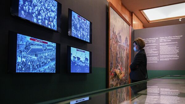 Посетительница просматривает кинодокументы на выставке Триумф победителей в Музее Победы в Москве. 