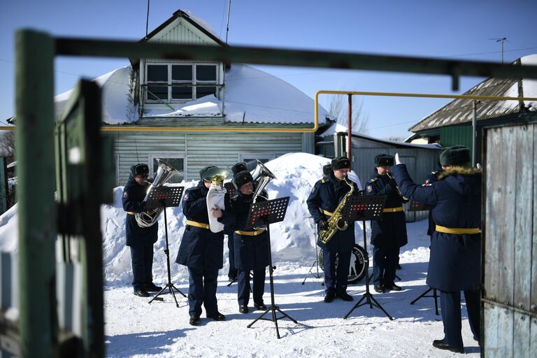 Военнослужащие соединения специального назначения поздравляют участницу Великой Отечественной войны Галину Александровну Дегтяреву возле ее дома в Новосибирске с наступающим Международным женским днем и днем рождения