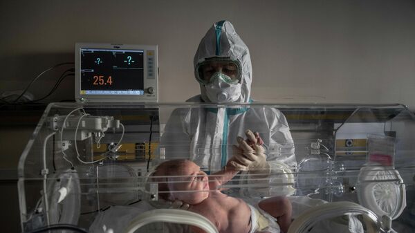 Медицинский работник и новорожденный ребенок в инфекционной больнице № 2, Москва, Россия